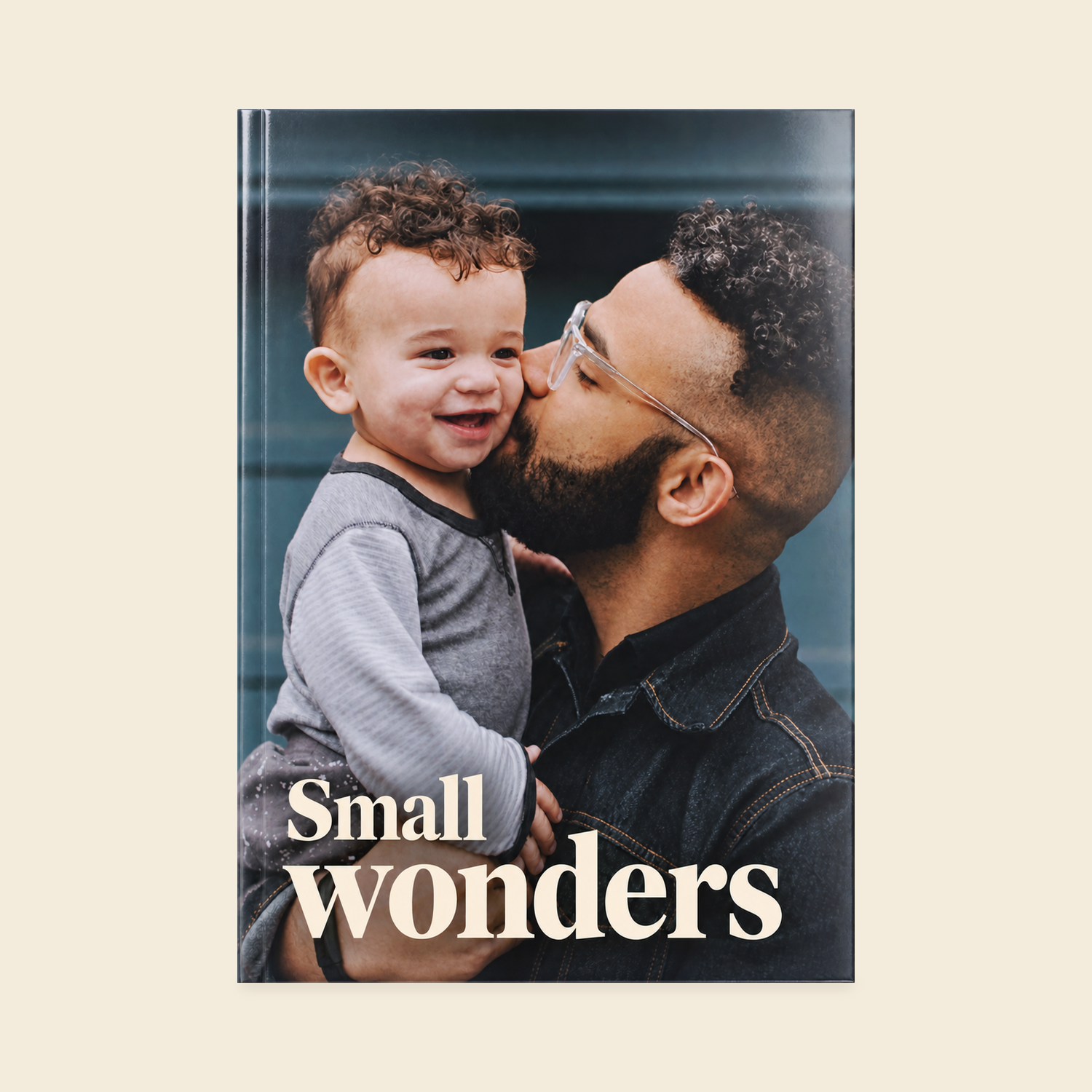 A4 portrait softcover photo book with a Small Wonders cover showing a father kissing his smiling child.