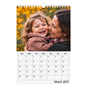 Picsme A5 single-page photo calendar showing a mother and laughing young daughter and the March 2027 date grid with white Wire-O binding and a white hanger.