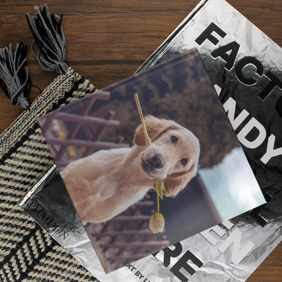 Lifestyle image of a square hardcover personalised photo book printed in the UK using FSC-certified paper
